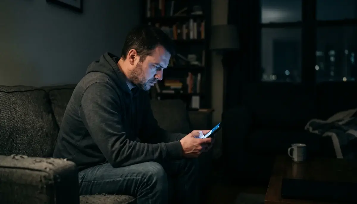 Sázkař u telefonu pozdě v noci s aplikací sázkovky